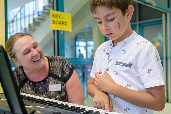 Keyboardlehrerin Annelie Seifert erklärt einem Kind das Keyboard