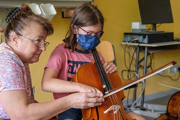 Cellolehrerin Brygida Lorenz erklärt einem Kind das Cello