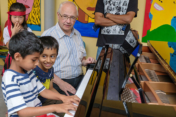 Klavierlehrer Patrick Mörtel erklärt Kindern das Instrument