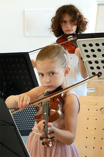 Zwei Violinenschüler musizieren auf ihren Instrumenten